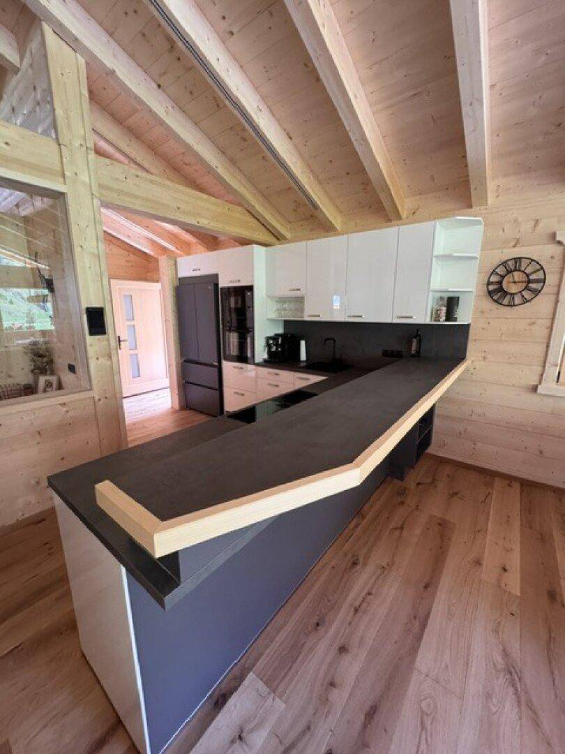 Moderne Küche mit langer Theke und integrierten Geräten im Holzchalet-Stil.
