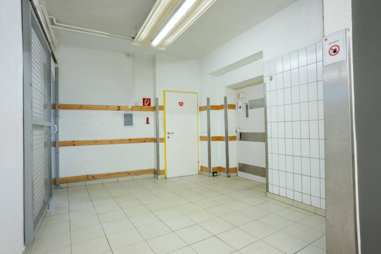 Geräumiger Flur mit Gitterabtrennung und funktionaler Beleuchtung.