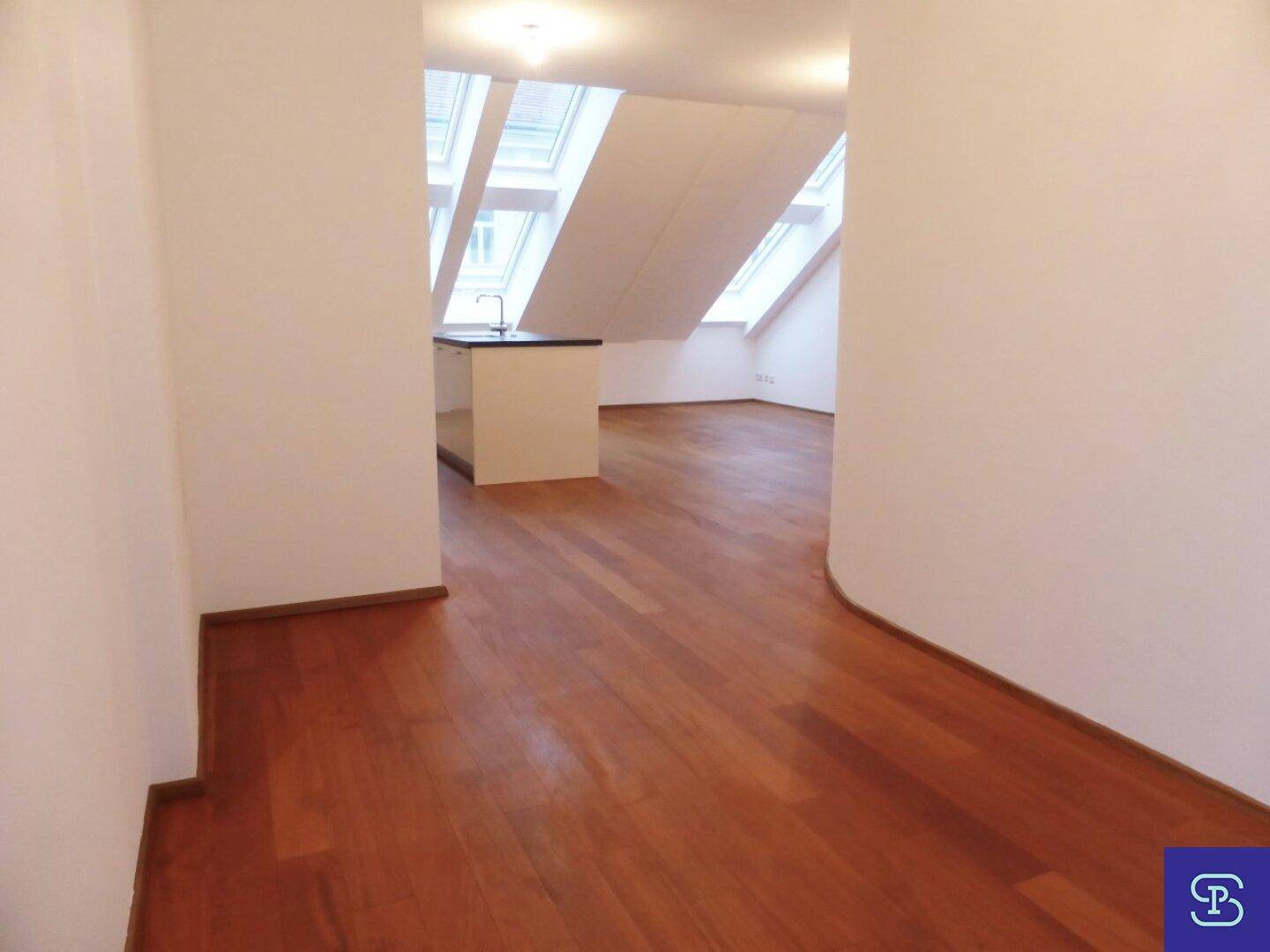 Offener Wohnbereich mit Holzboden und Blick auf die integrierte Küche.