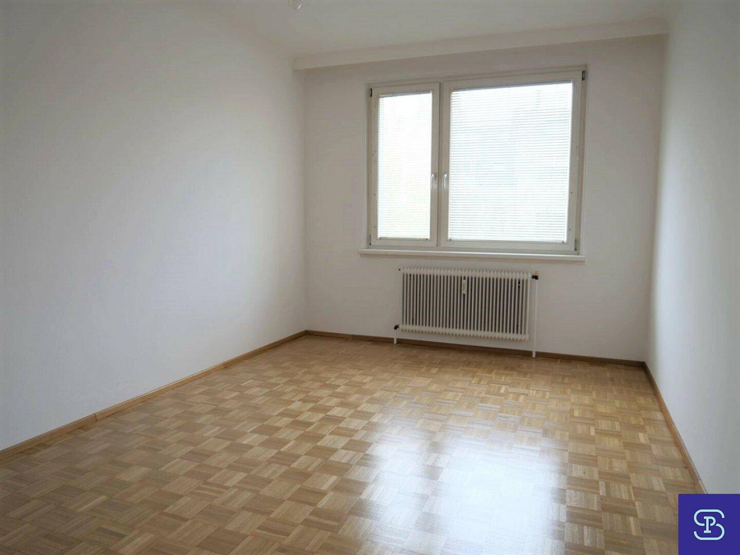 Kleineres Zimmer mit Parkettboden und Fenster mit Jalousien, geeignet als Schlaf- oder Kinderzimmer.