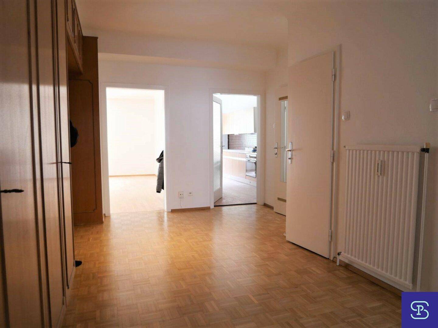 Geräumiger Flur mit Parkettboden und Zugang zu mehreren Zimmern.