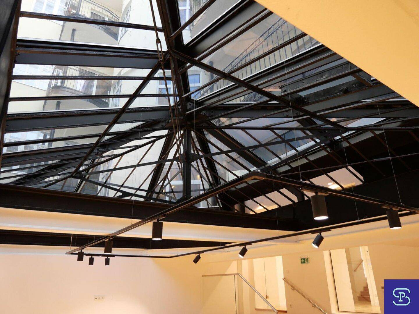 Detailansicht der modernen Glasdachkonstruktion mit integrierter Schienenbeleuchtung.