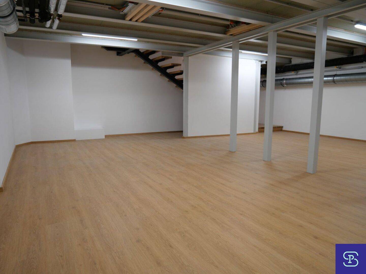 Geräumiger Kellerraum mit Laminatboden und Treppenzugang.