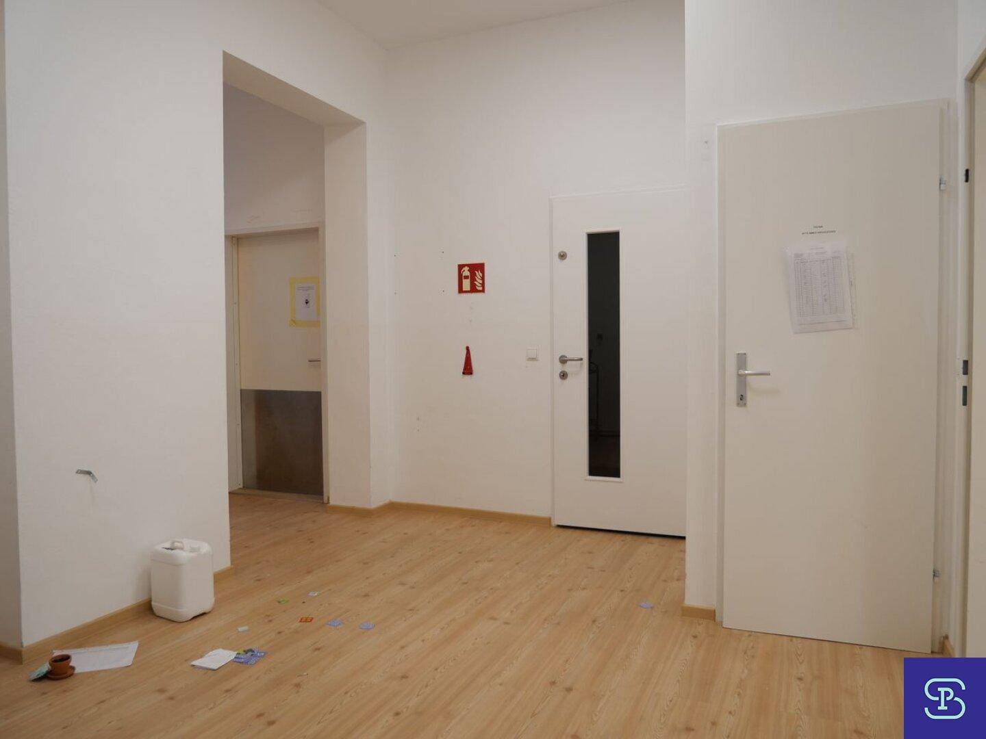 Langer, heller Flur mit Laminatboden und mehreren Türen, der zu weiteren Räumen führt.