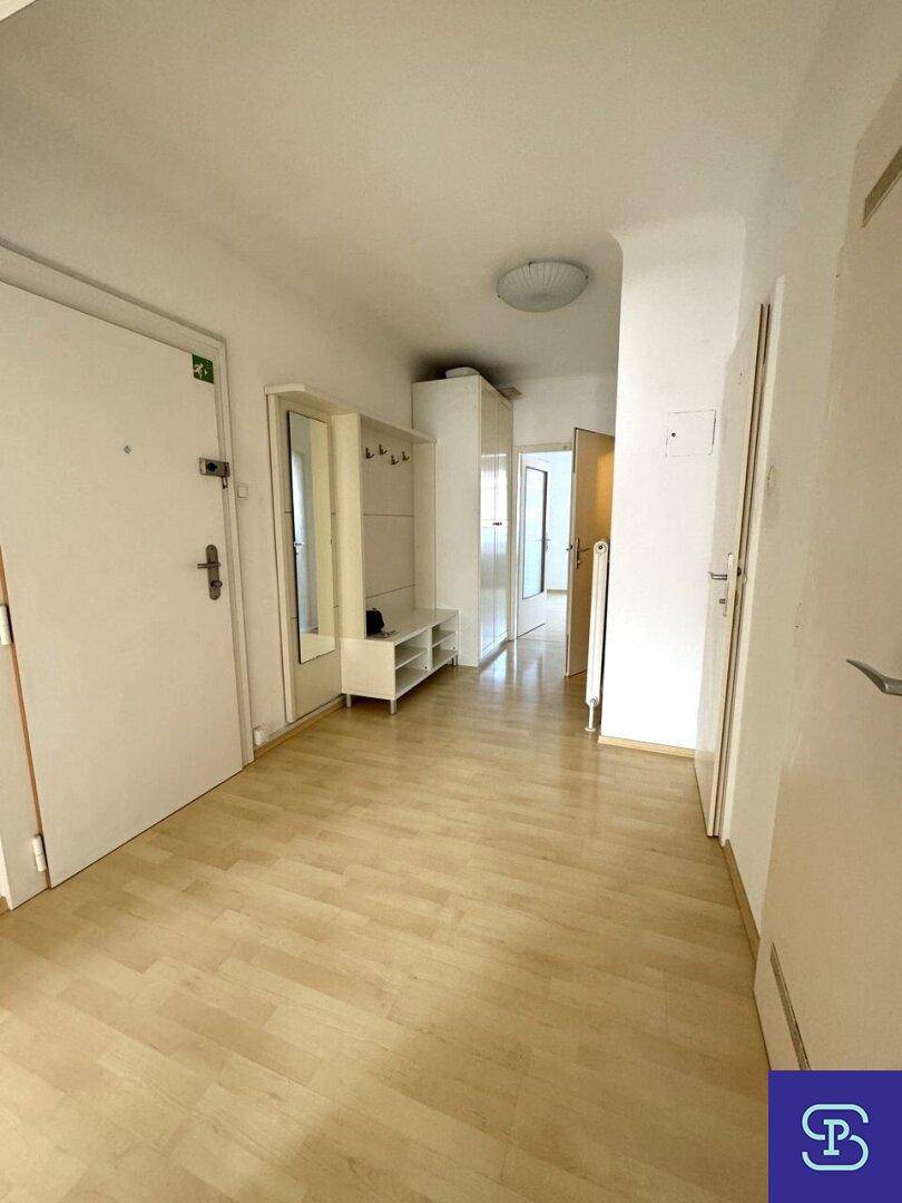 Heller Flur mit Laminatboden, Garderobe und mehreren Türen zu den angrenzenden Zimmern.