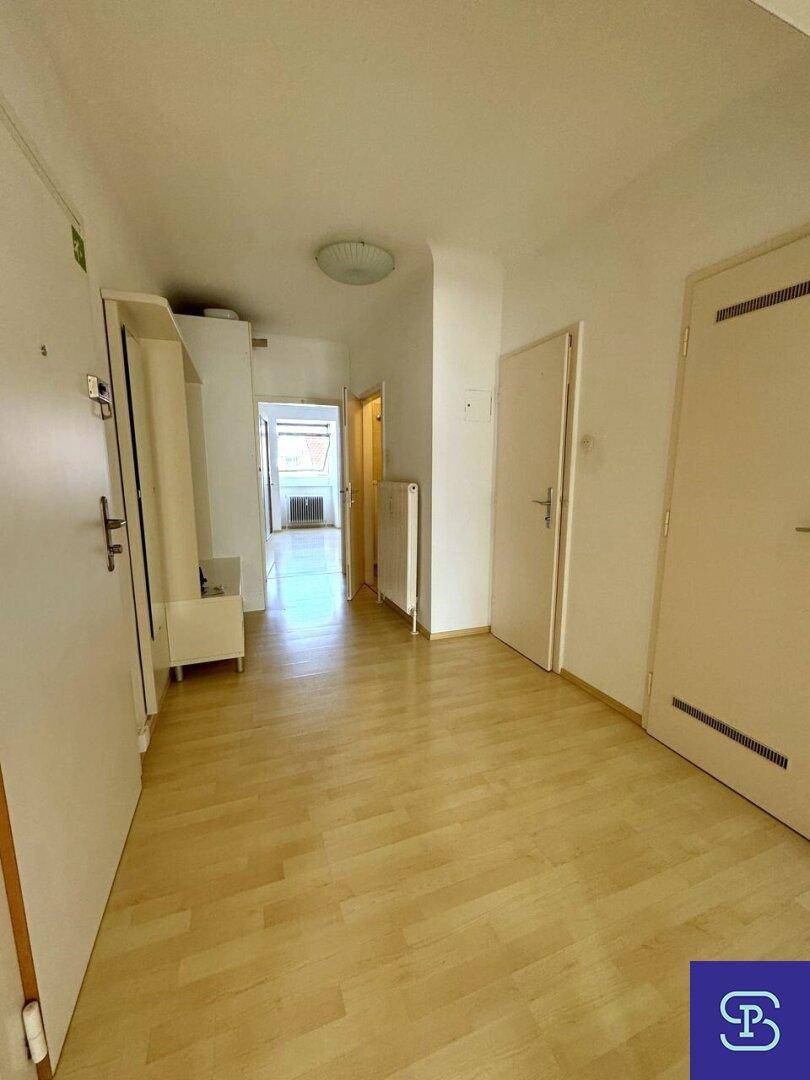 Geräumiger Flur mit hellem Laminatboden und Garderobe, der zu weiteren Räumen führt.