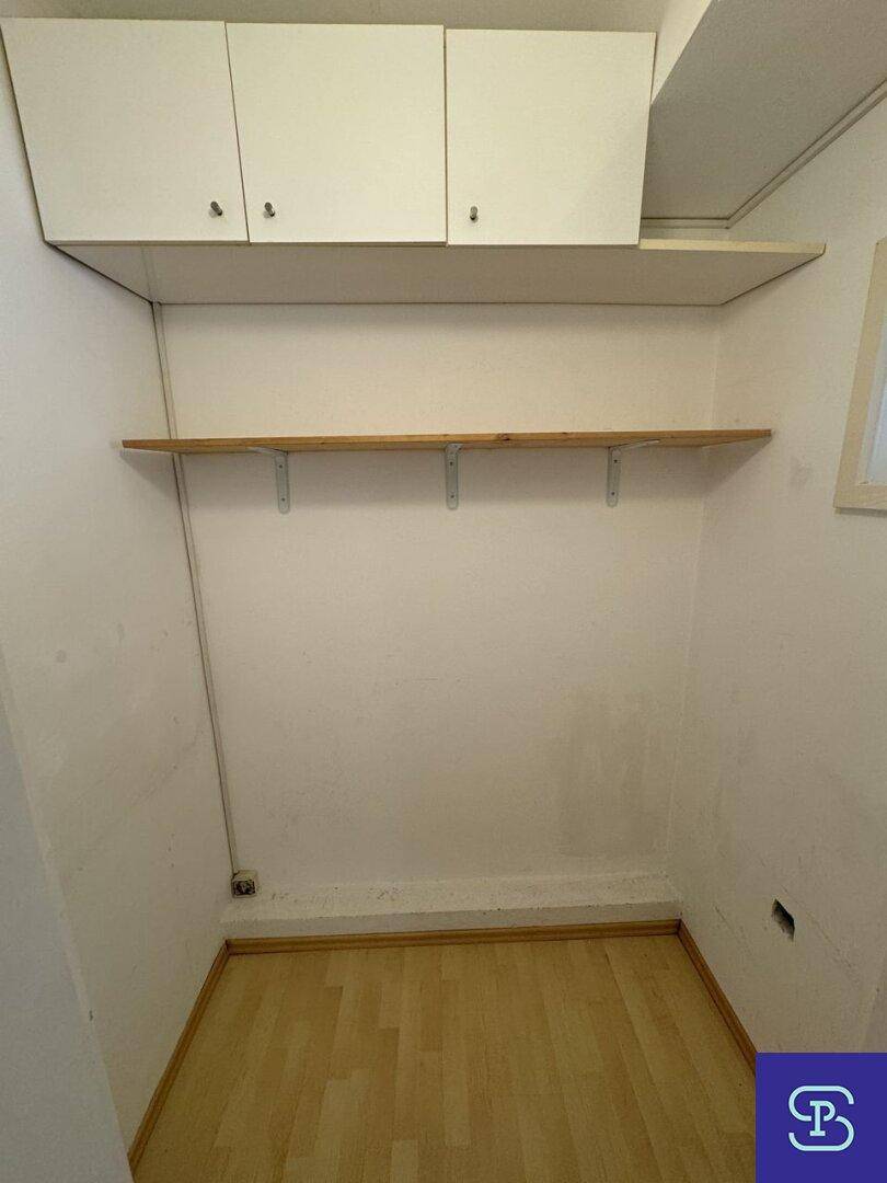 Kleiner Abstellraum mit Regalen und hellem Laminatboden für zusätzlichen Stauraum.