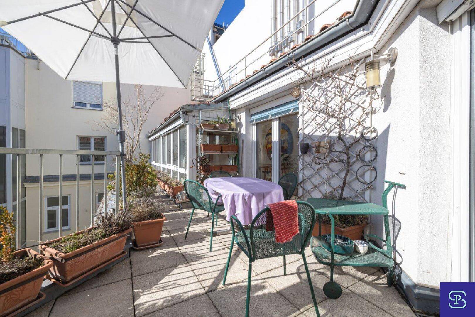 Geräumige Dachterrasse mit Sitzgelegenheiten, Pflanzen und einem großen Sonnenschirm.
