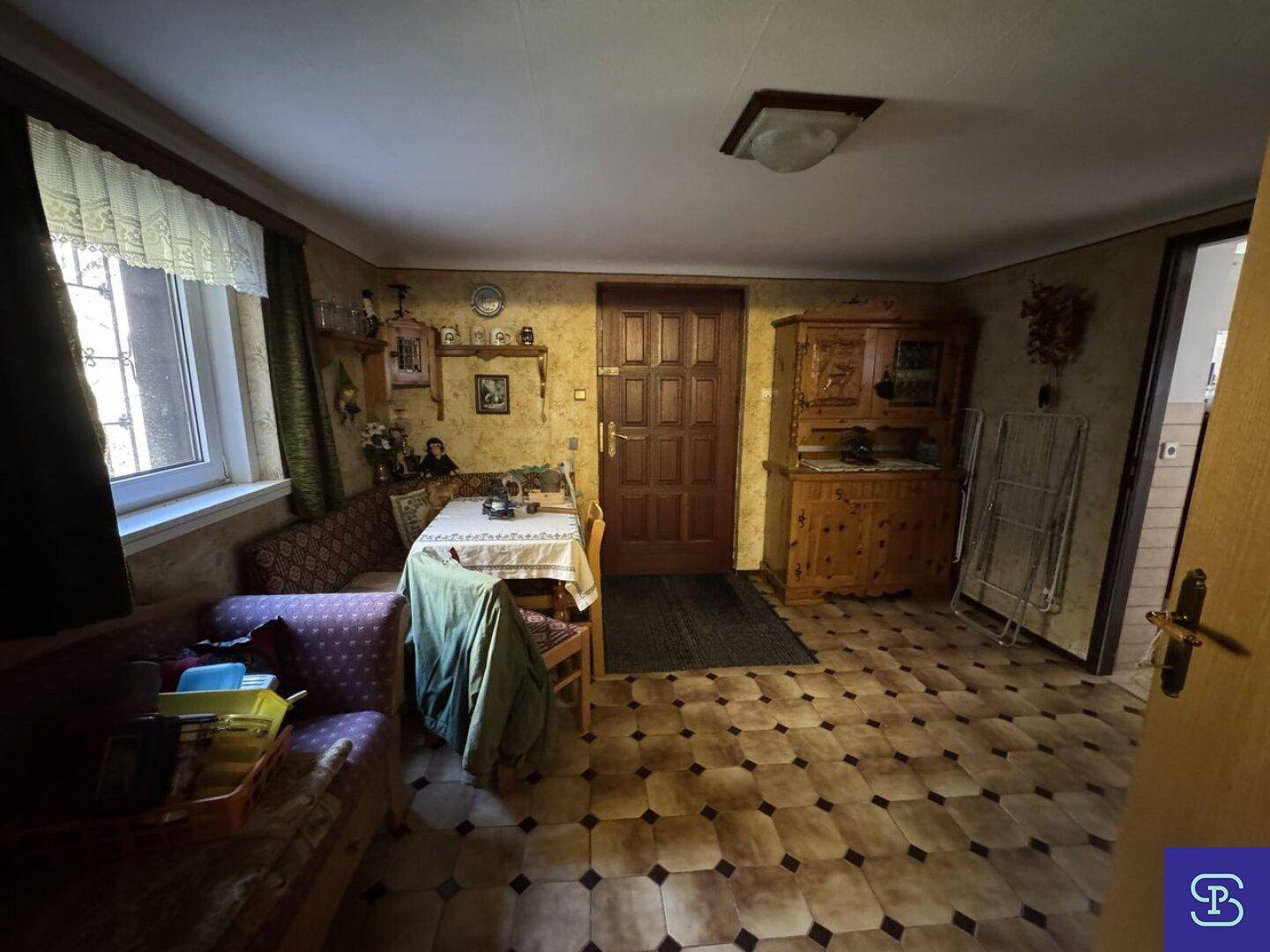 Gemütlicher Essbereich mit Eckbank, Fliesenboden und traditionellen Holzmöbeln.