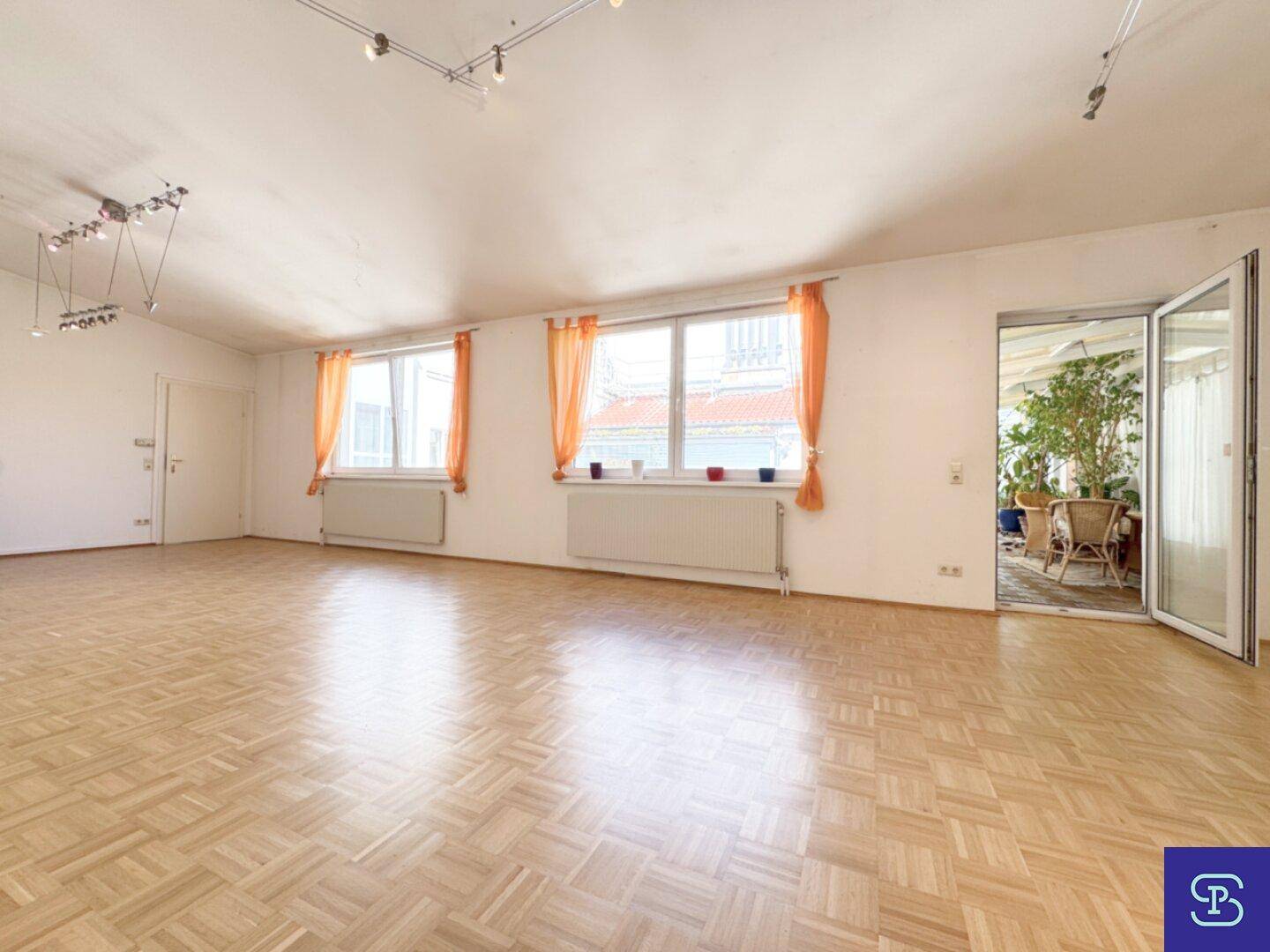 Helles Wohnzimmer mit Parkettboden und Zugang zu einem möglichen Außenbereich.