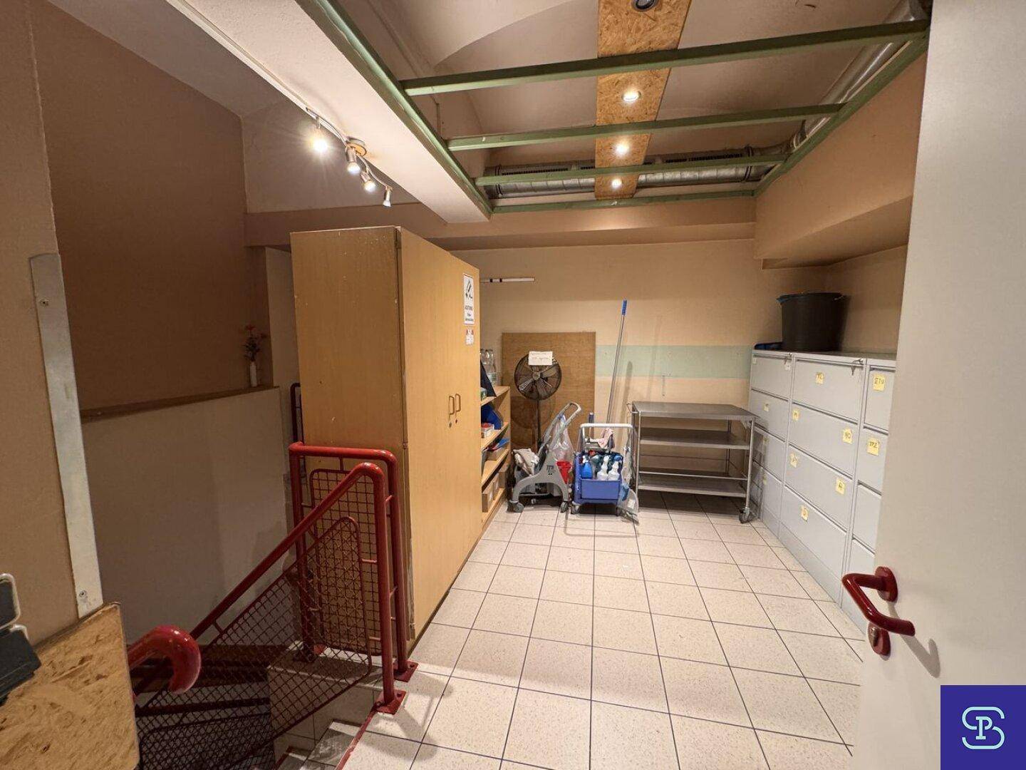Praktischer Lagerraum mit Regalen und Zugang zu einer Treppe, ideal für die Aufbewahrung von Materialien und Geräten.