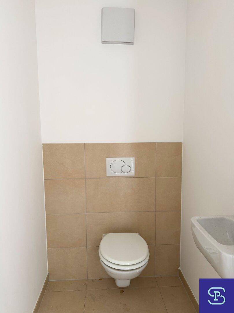 Modernes Gäste-WC mit Wand-WC und kleinem Waschbecken, in neutralen Farbtönen gehalten.