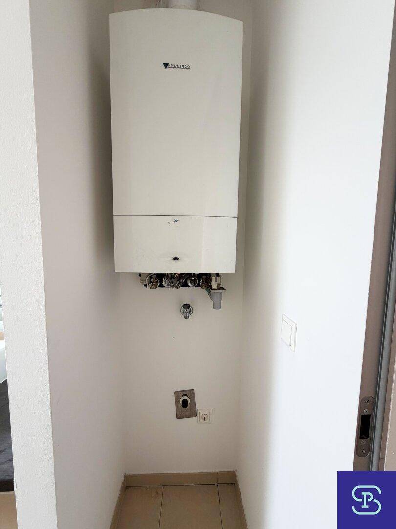 Kleiner Hauswirtschaftsraum mit Gastherme und Anschlüssen für Waschmaschine oder Trockner.