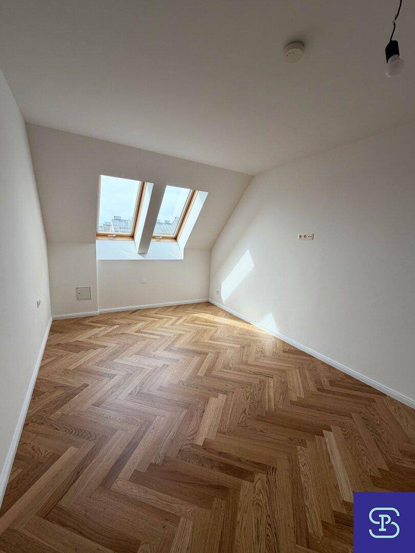 Helles Dachgeschosszimmer mit Fischgrätparkett und zwei Dachfenstern, bietet vielseitige Nutzungsmöglichkeiten.