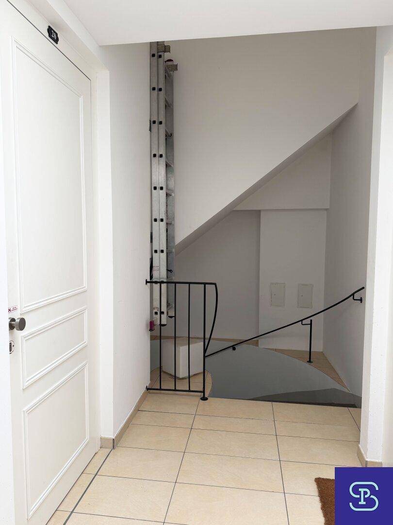 Eingangsbereich mit Fliesenboden, Treppe und Zugang zu einem Aufzug, der die Etagen verbindet.