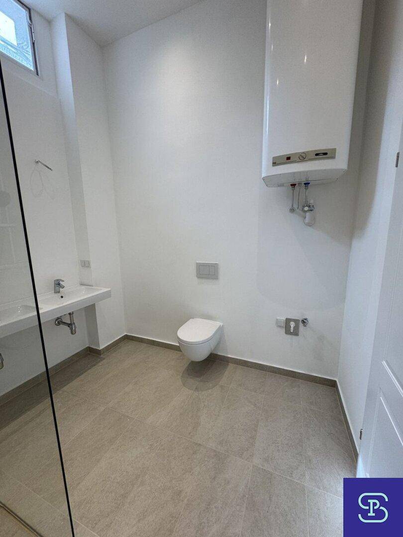 Modernes Badezimmer mit Wand-WC, Doppelwaschbecken und Fenster.