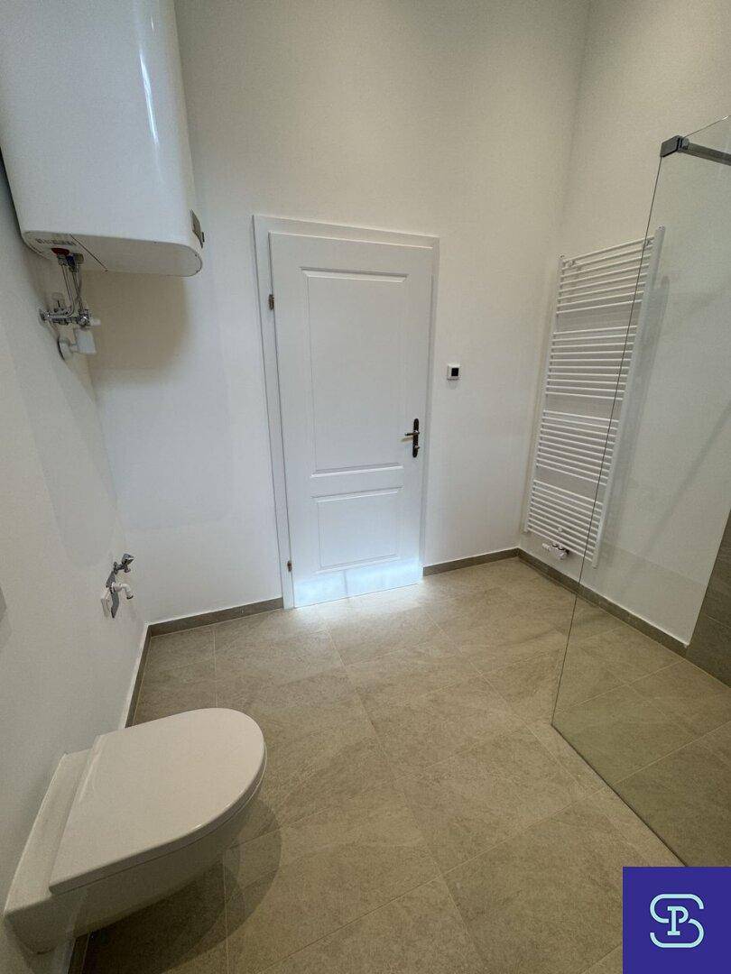 Modernes Badezimmer mit begehbarer Dusche, Wand-WC und beheiztem Handtuchhalter.