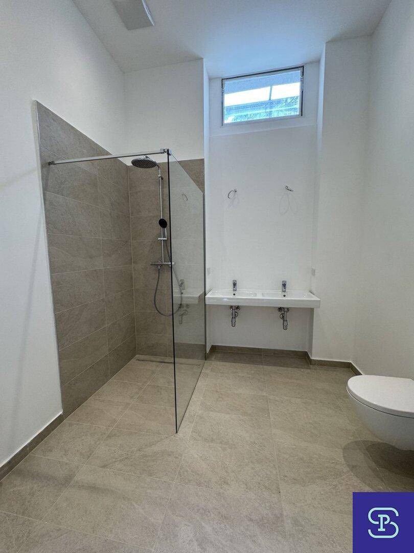 Modernes Badezimmer mit begehbarer Dusche, Doppelwaschbecken und Fenster.