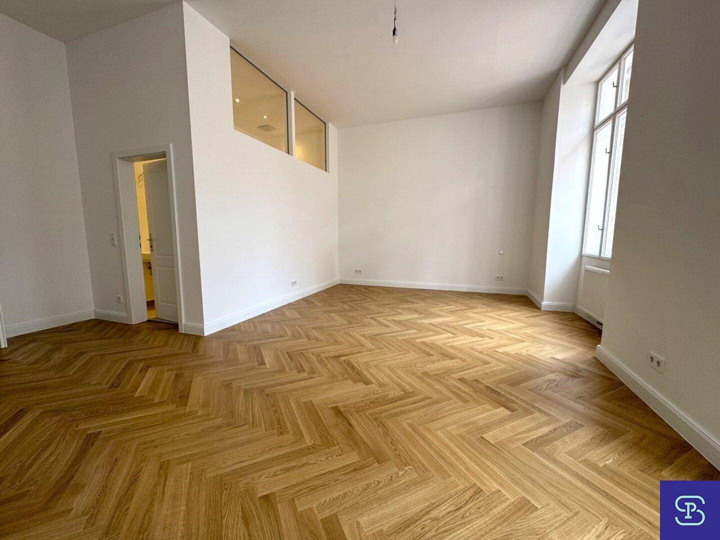 Geräumiges Wohnzimmer mit elegantem Fischgrätparkett und modernen Oberlichtern.