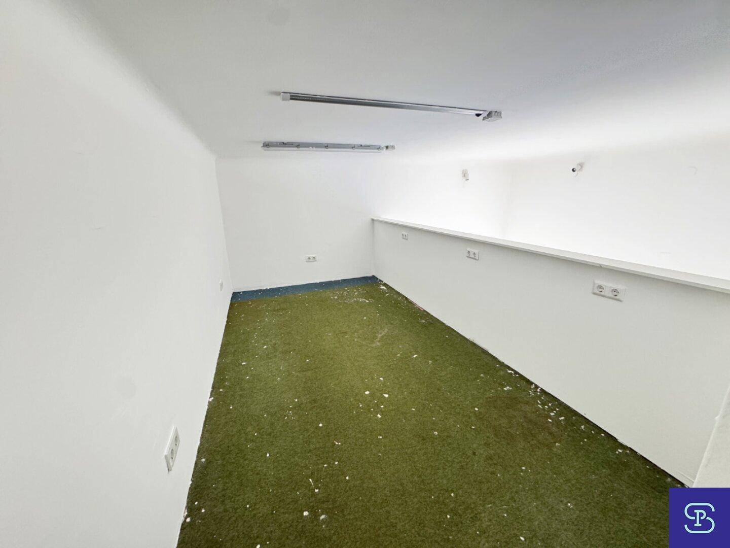 Kleiner Raum im Obergeschoss mit grünem Teppichboden und einfacher Beleuchtung, nutzbar als Lager oder Abstellraum.