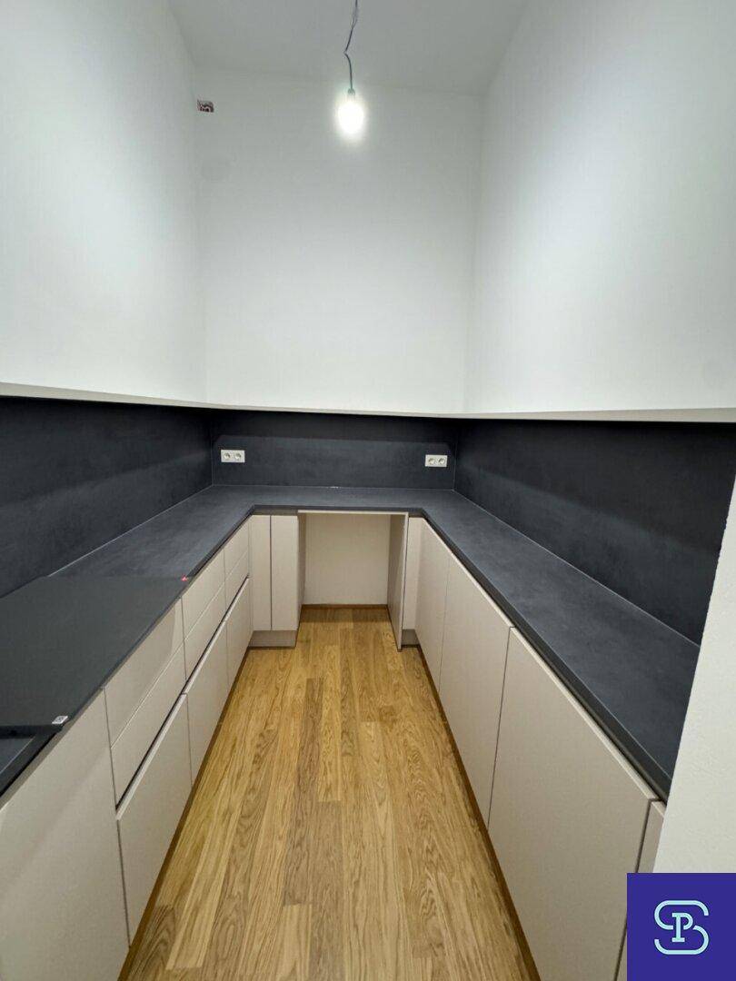 U-förmige Küche mit viel Arbeitsfläche und Stauraum, ausgestattet mit Holzboden.