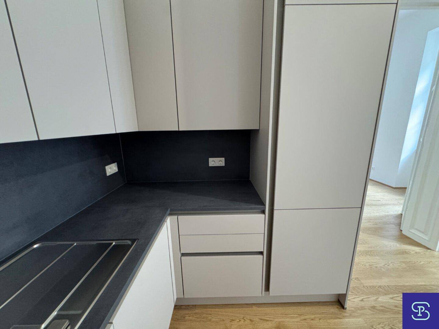 Integrierte Küchenschränke mit Stauraum und Platz für einen Kühlschrank in der modernen Küchenzeile.
