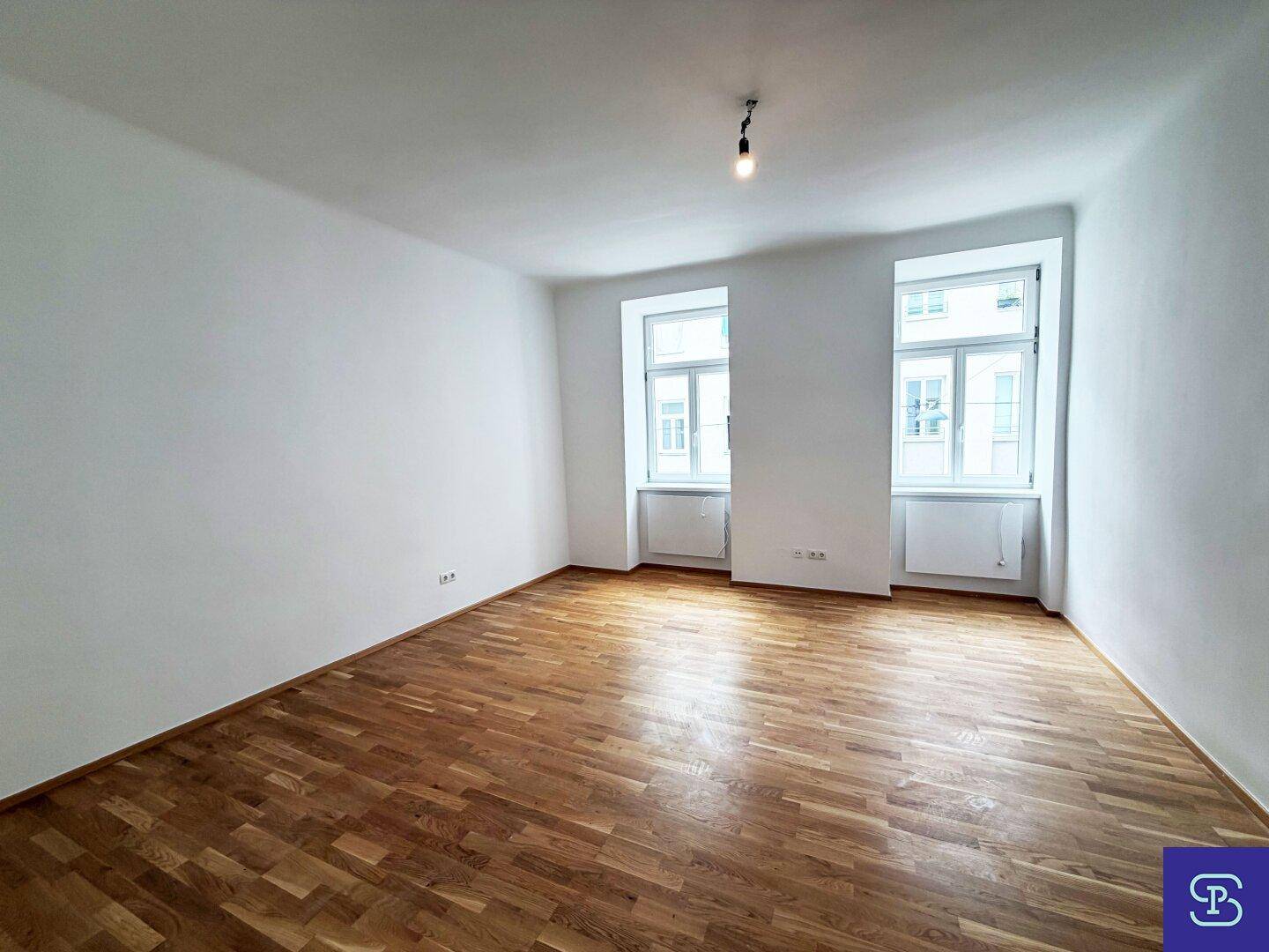 Geräumiges, helles Zimmer mit zwei großen Fenstern und schönem Parkettboden.