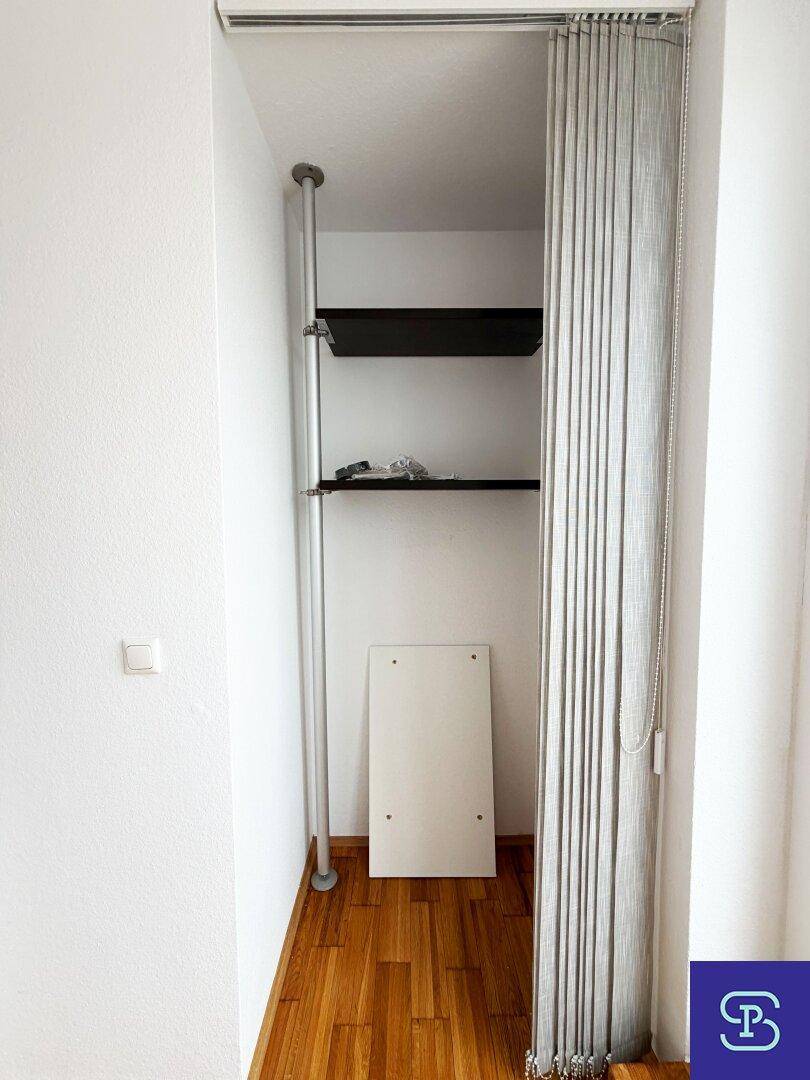 Praktischer Abstellraum mit Regalsystem und Vorhang, bietet zusätzlichen Stauraum.