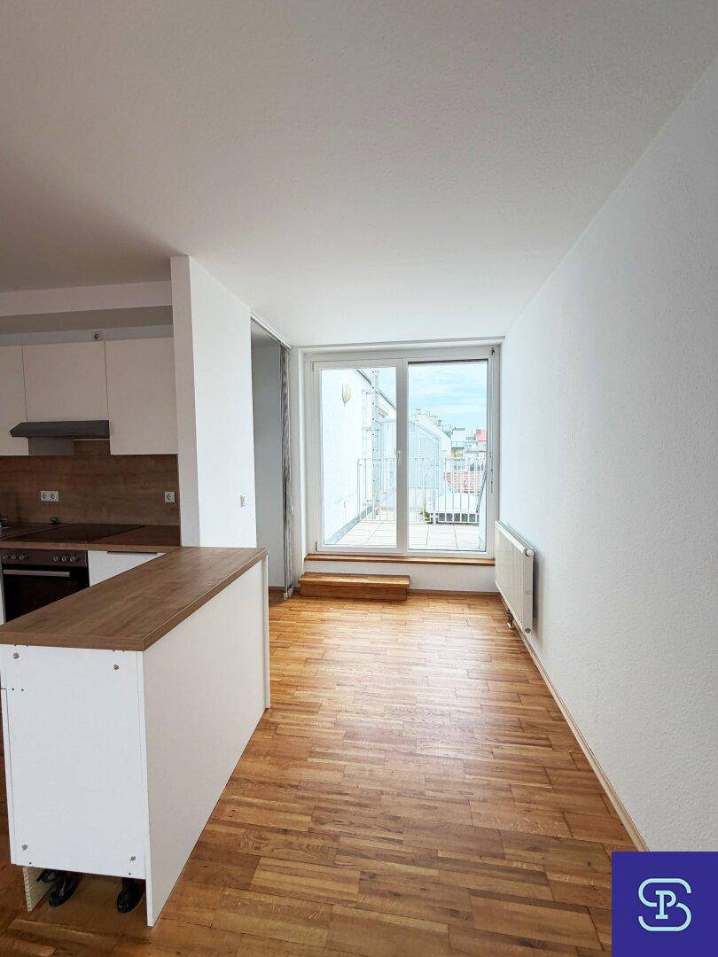 Offener Wohnbereich mit Parkettboden und Zugang zu einem Balkon, hell und einladend.