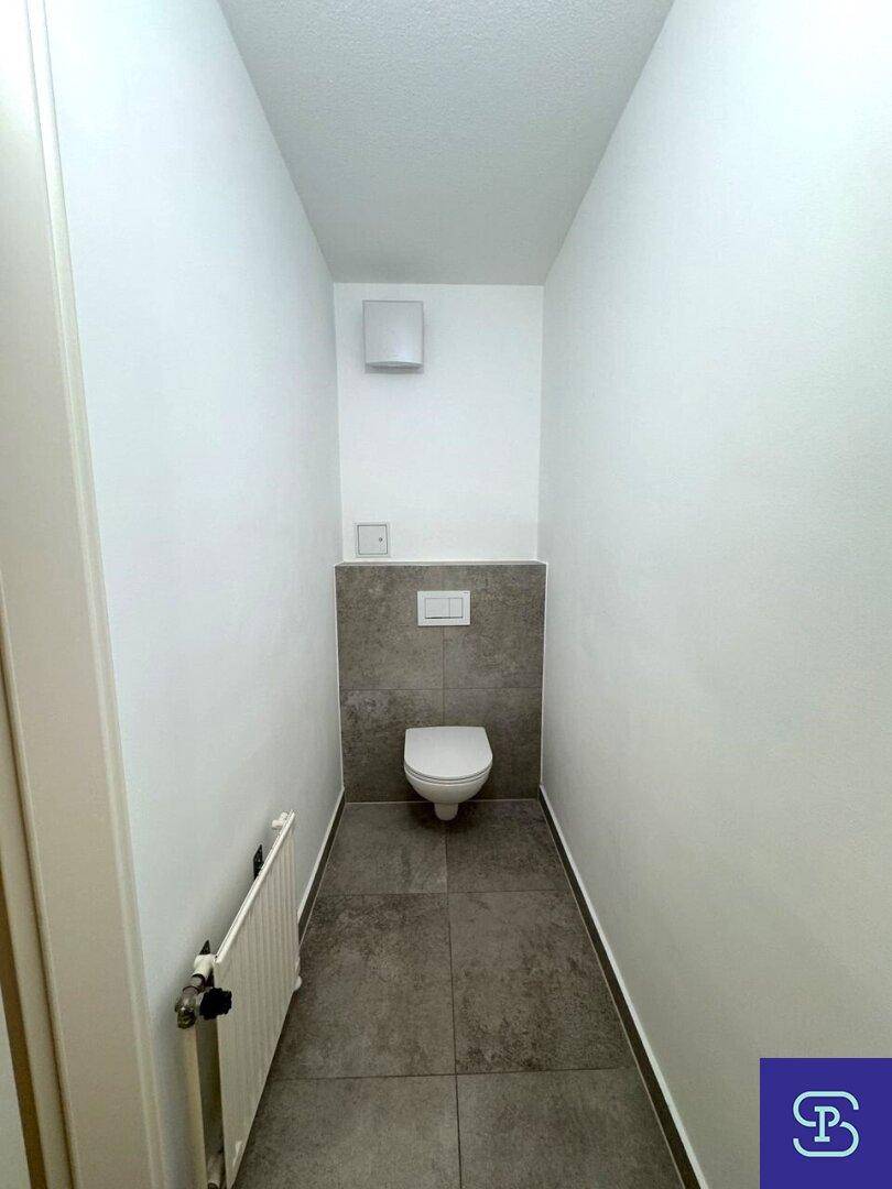 Modernes Gäste-WC mit Wand-WC und Fliesen im unteren Bereich.