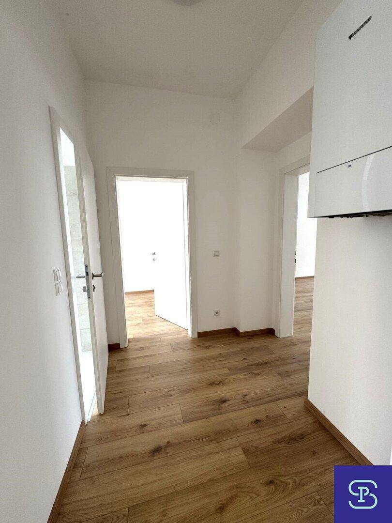 Heller Flur mit Laminatboden und mehreren Türen, die zu den angrenzenden Zimmern führen.