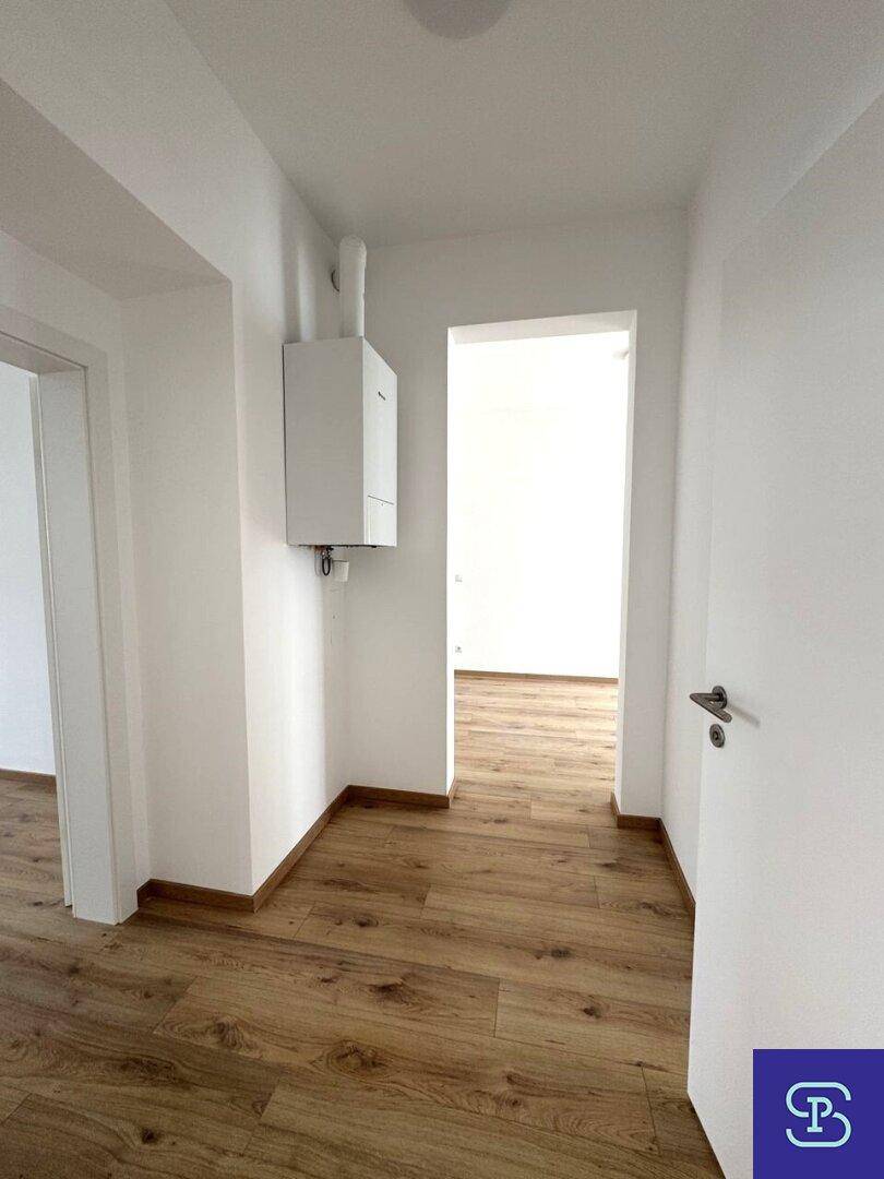 Flur mit Laminatboden und einer Heizungsanlage an der Wand, die den Raum beheizt.