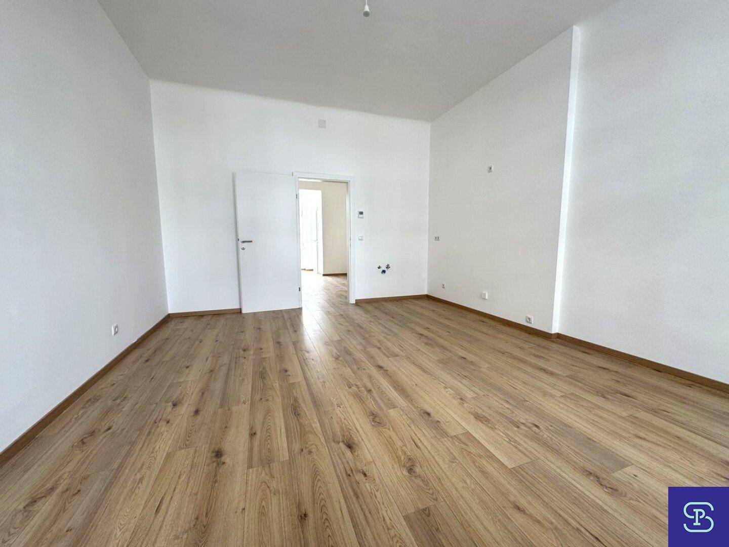 Geräumiges, leeres Zimmer mit Laminatboden und weiß gestrichenen Wänden, ideal für Wohnzwecke.