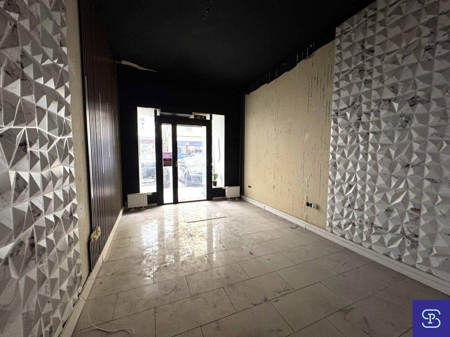 Eingangsbereich mit modernen 3D-Wandpaneelen und dunkler Decke, Fliesenboden.