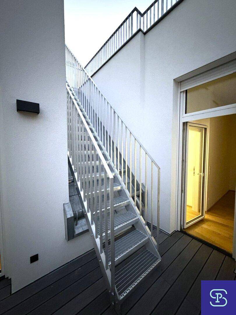 Moderne Außentreppe aus Metall führt zu einer oberen Terrasse oder einem Balkon.
