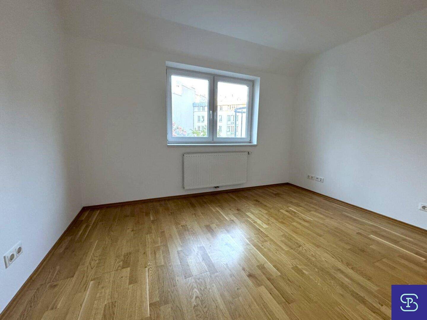 Ruhiges Schlafzimmer mit hellem Holzboden und einem Fenster, das den Raum erhellt.