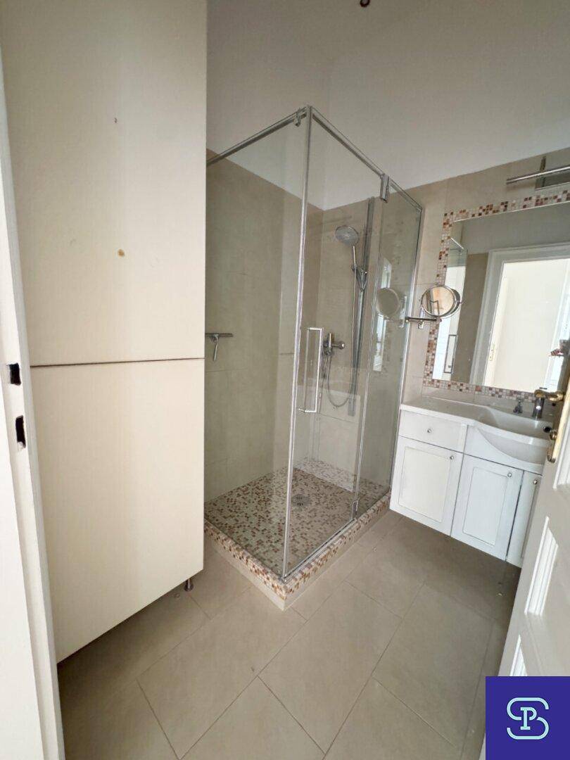 Modernes Badezimmer mit geräumiger Duschkabine, Einzelwaschbecken und praktischem Hochschrank.