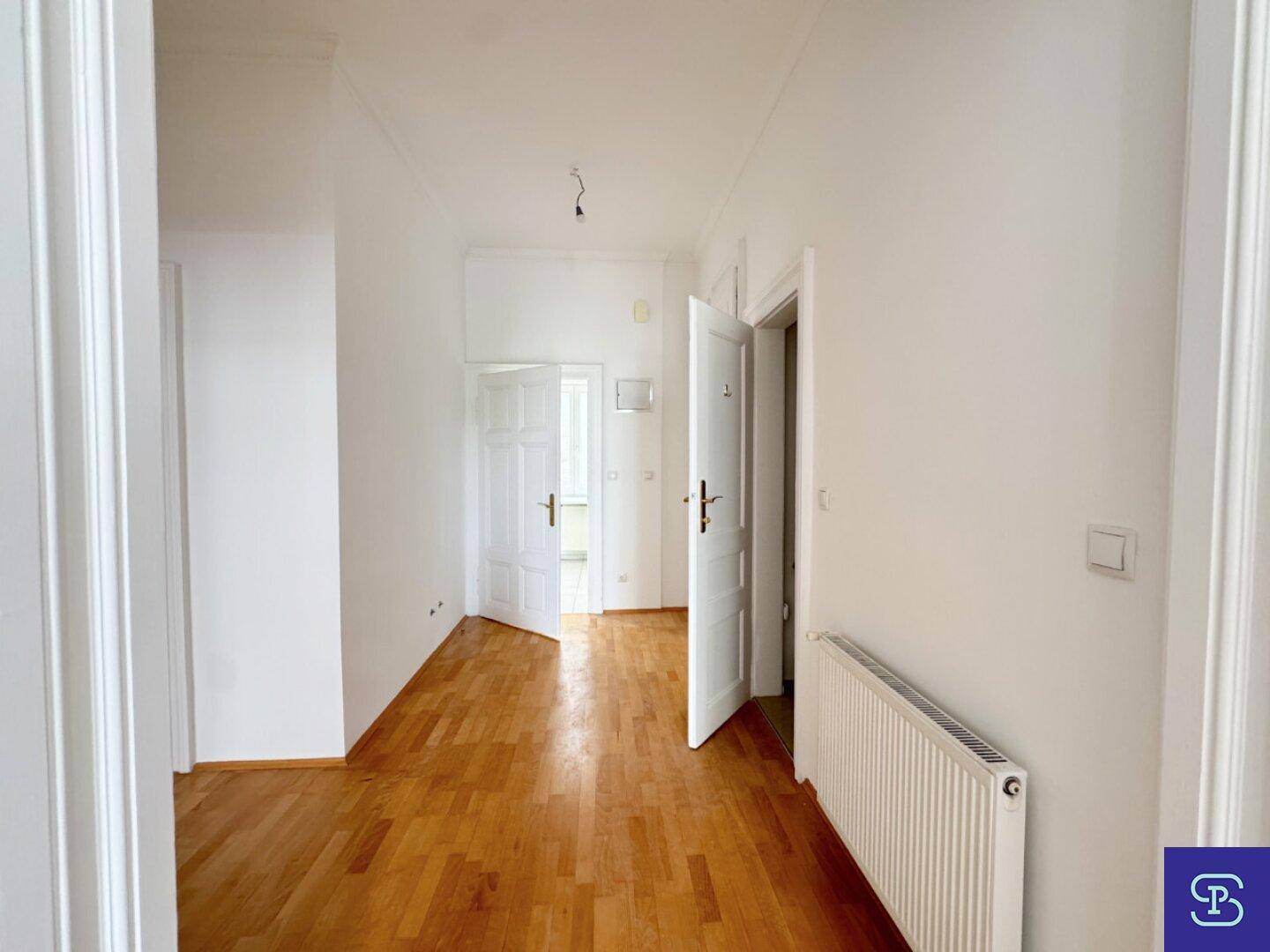 Heller Flur mit Holzboden und Heizkörper, der die verschiedenen Wohnbereiche verbindet.