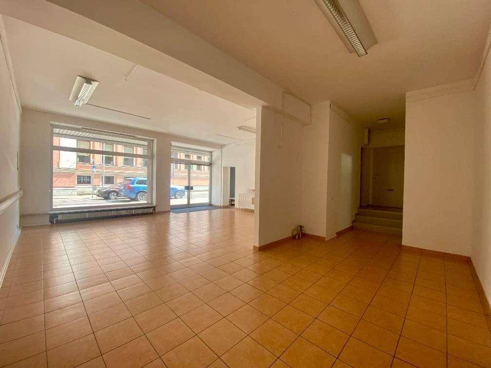 Heller, offener Gewerberaum mit großen Fenstern zur Straße und praktischem Fliesenboden.