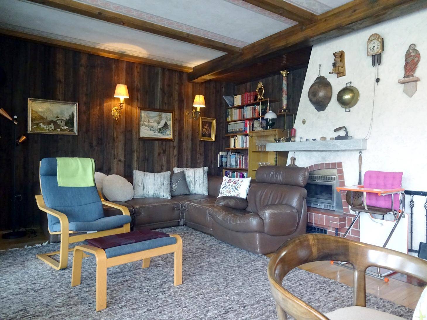 Gemütliches Wohnzimmer im Landhausstil mit Holzwänden, Kamin und bequemen Sofas.