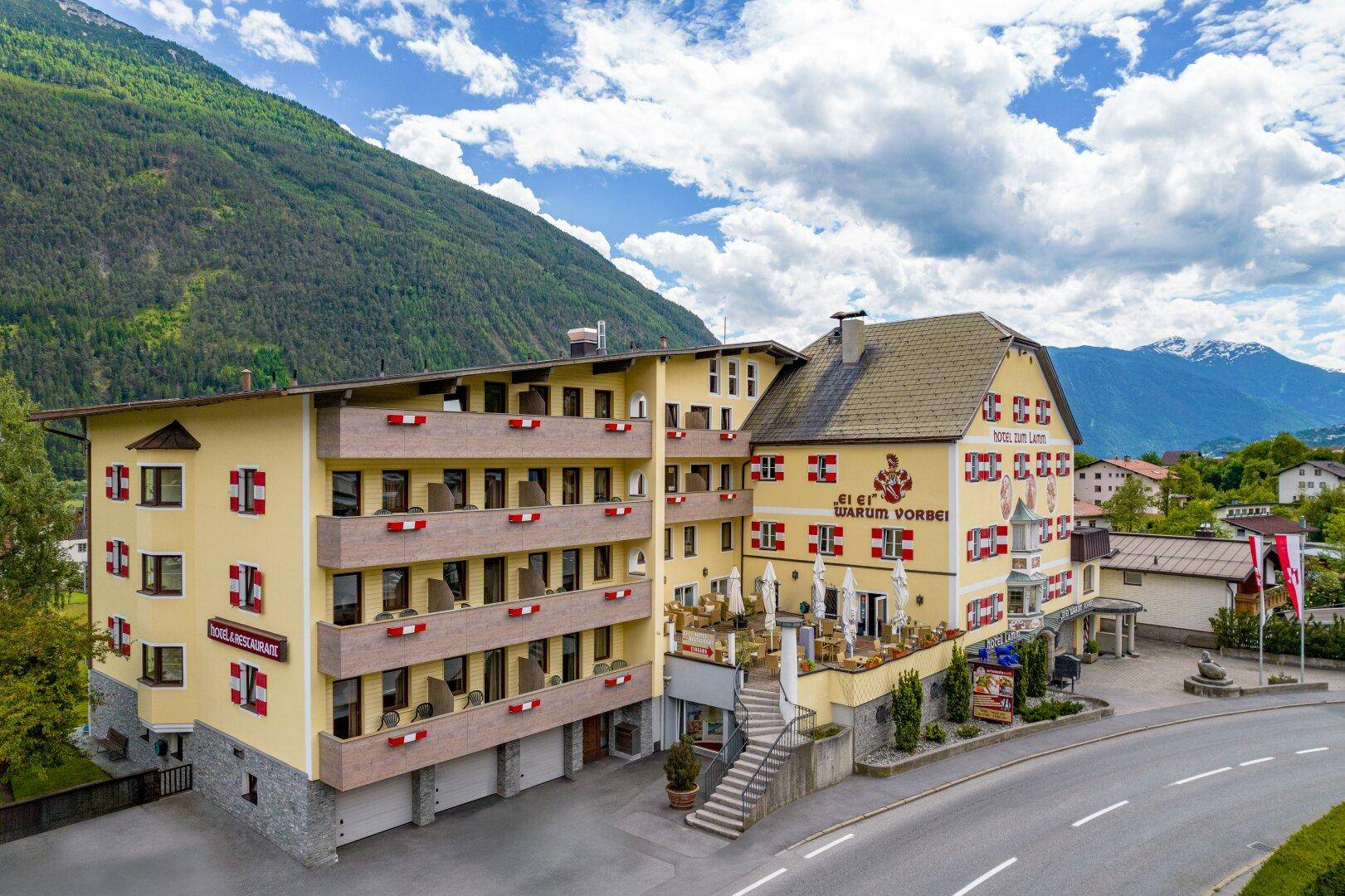 Das Hotelgebäude mit seinen Balkonen und der Außenterrasse fügt sich harmonisch in die alpine Landschaft ein.