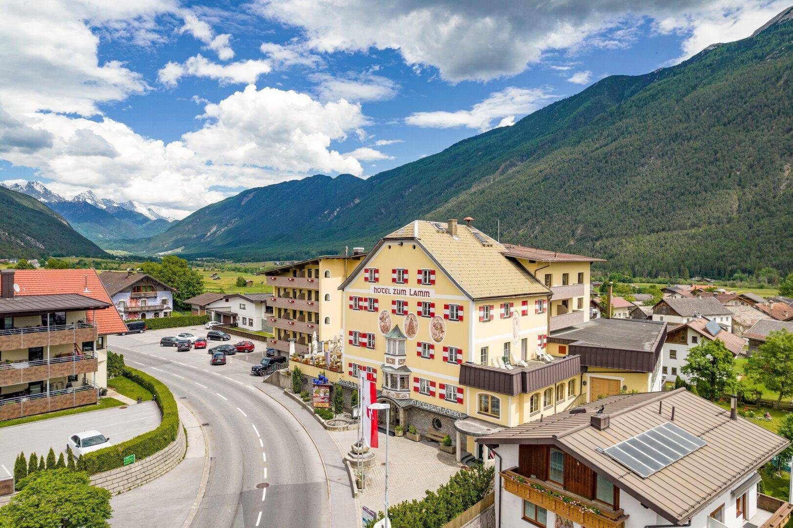 Panoramablick auf das Hotel und die umliegende Siedlung, mit weitem Blick über das Tal und die schneebedeckten Gipfel.