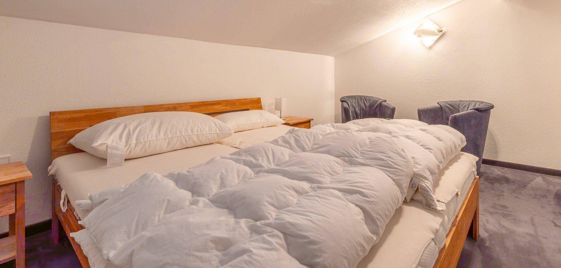 Gemütliches Schlafzimmer mit Doppelbett und Dachschräge im oberen Stockwerk.