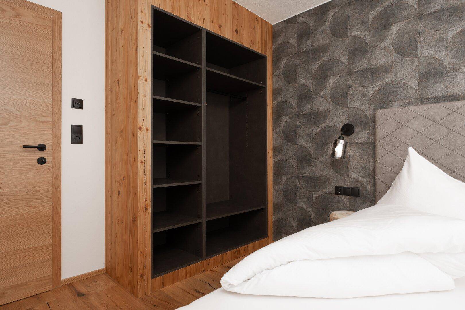 Praktischer, offener Einbauschrank im Schlafzimmer bietet viel Stauraum für Kleidung und persönliche Gegenstände.