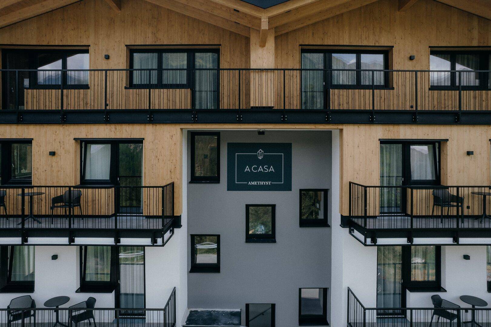 Detailansicht der modernen Fassade des Apartmenthauses mit Balkonen und dem Eingangsbereich.