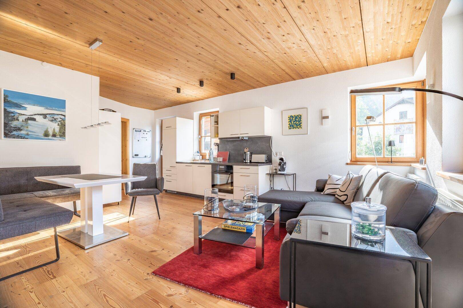 Geräumiger Wohn-Essbereich mit Holzboden, moderner Einrichtung und viel Tageslicht.