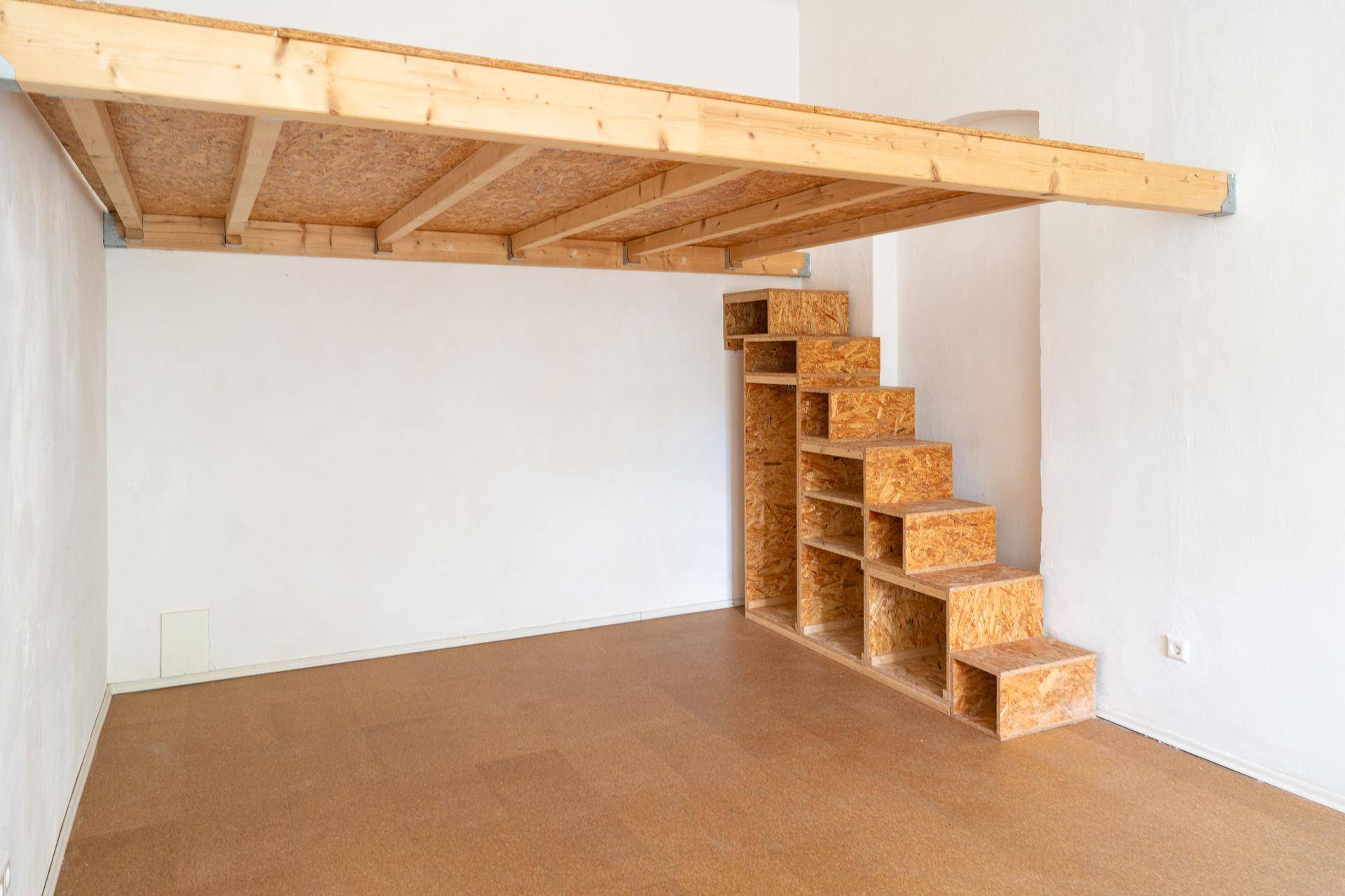 Detailansicht der stabilen Holzempore mit integrierter Treppe und Ablagefächern.