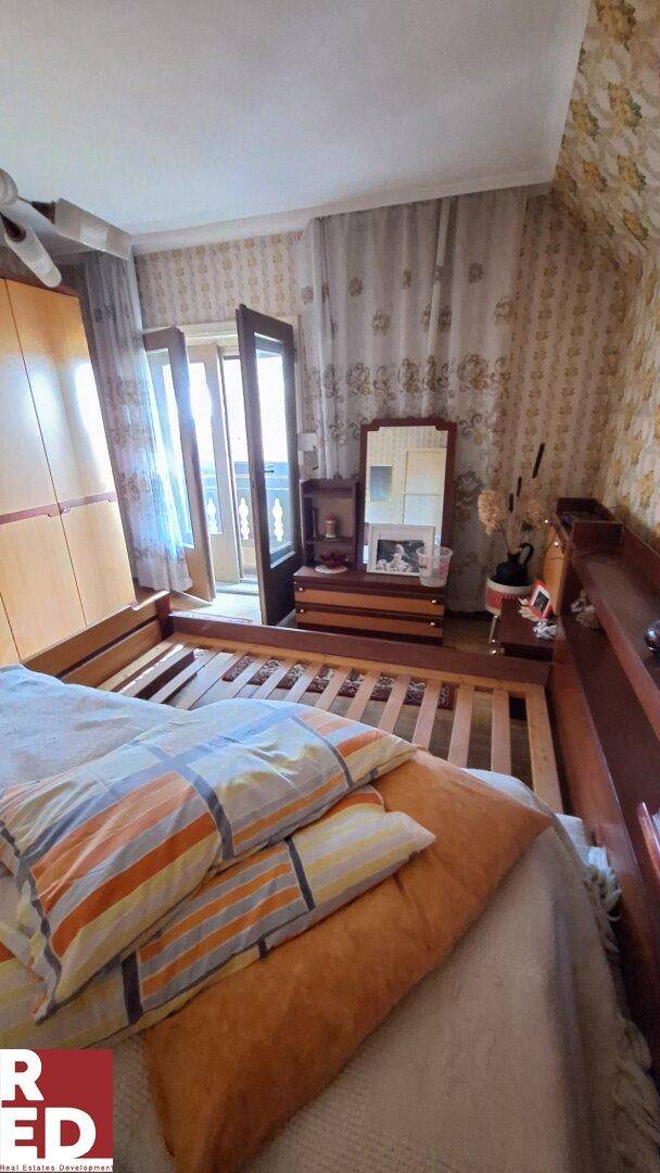 Gemütliches Schlafzimmer mit Doppelbett, Holzmöbeln und Zugang zu einem Balkon oder einer Terrasse.