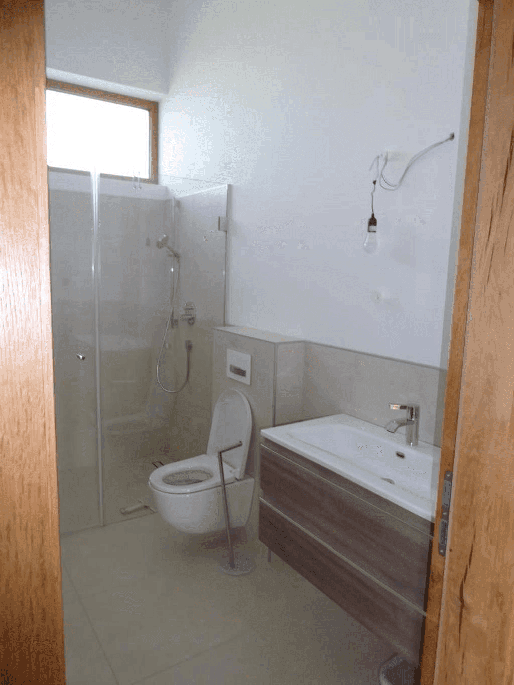 Modernes Badezimmer mit Dusche, wandhängendem WC, Einzelwaschbecken und Fenster.