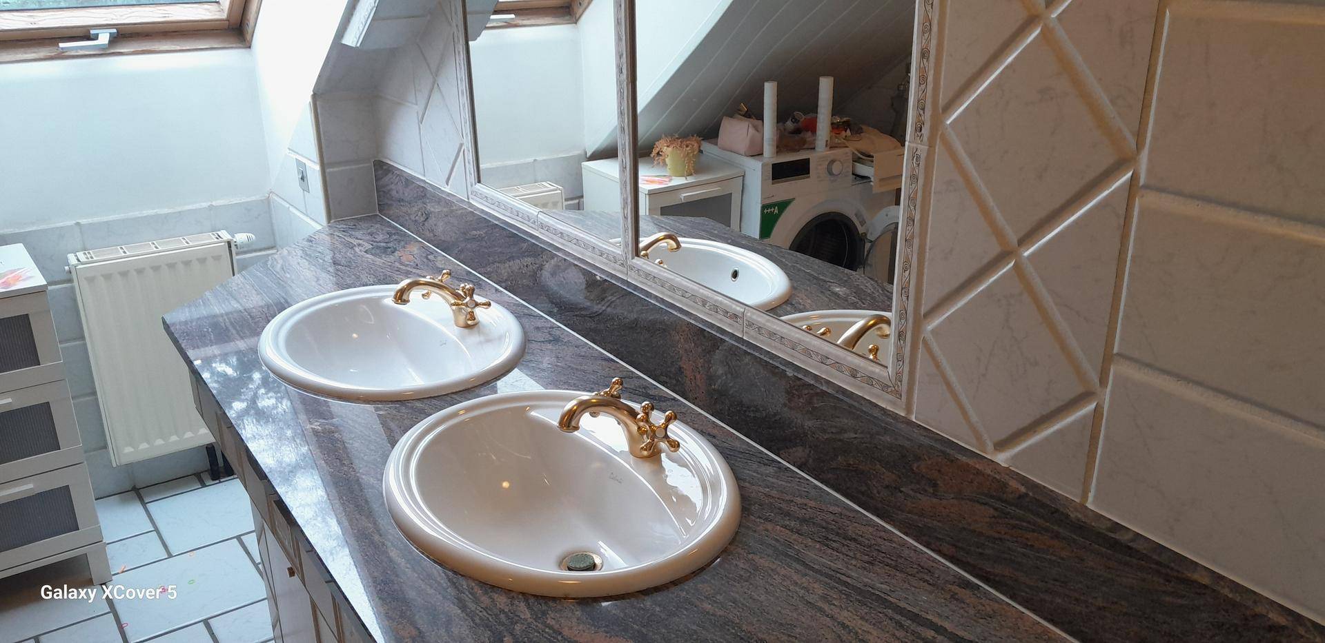 Badezimmer mit Doppelwaschbecken, großem Spiegel und Granit-Arbeitsplatte, bietet viel Platz.